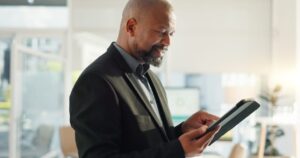 Un conseiller bancaire examine une demande de crédit sans justificatif devant un ordinateur et des documents d’identité.